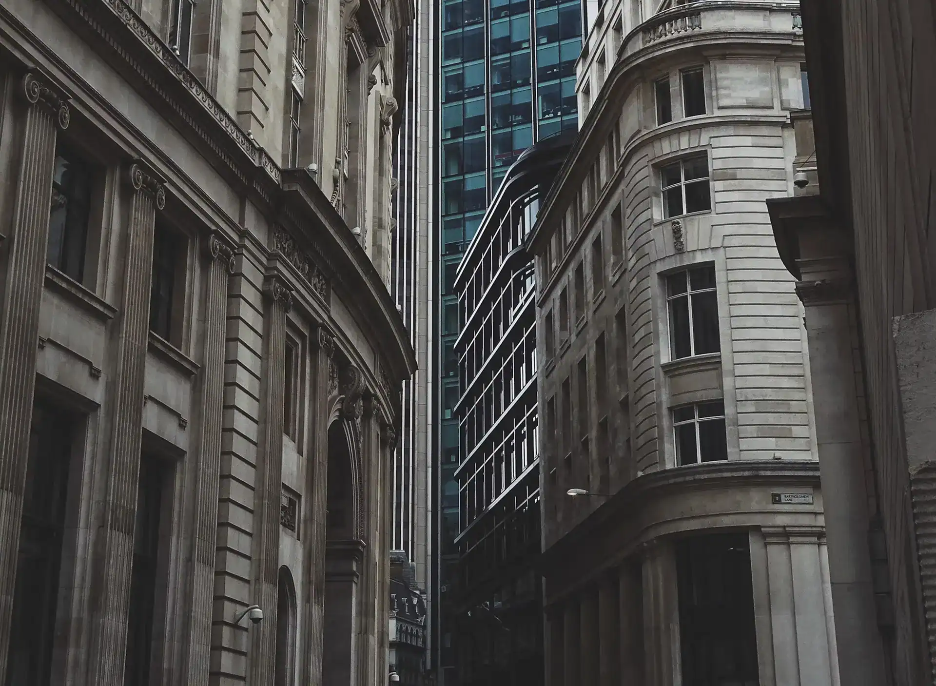 Modern urban cityscape featuring historic and contemporary office buildings in a dense financial district.
