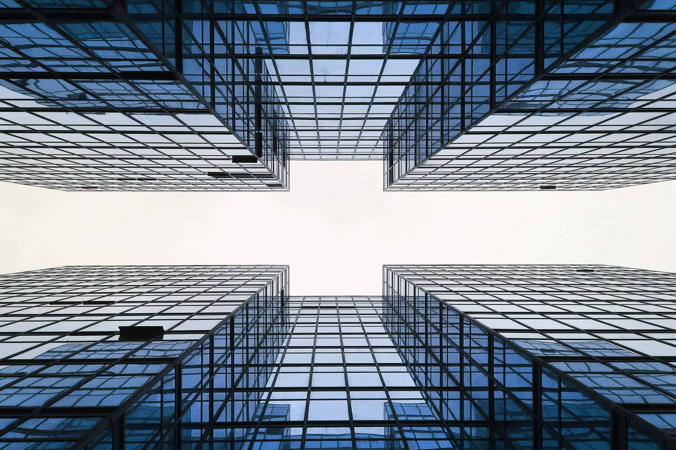 Modern glass office buildings with reflective facades in a cityscape.
